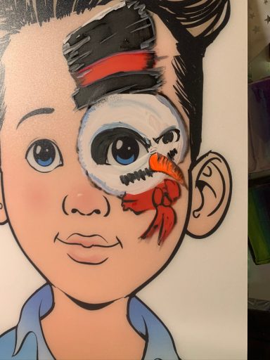 Junge mit beschnittener Frisur, bemaltem Gesicht und einem auffälligen Schildkrötenmotiv.