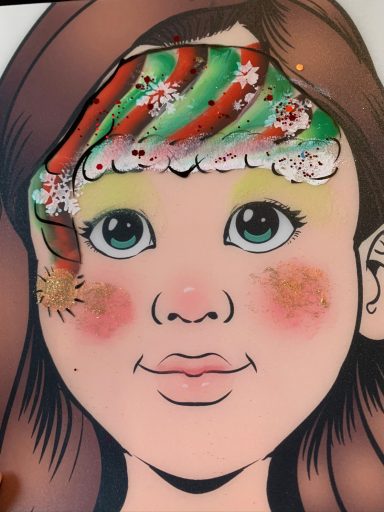 Ein kindliches Gesicht mit buntem, festlichem Schminckmotiv im Haar.