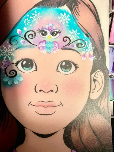 Mädchen mit buntem Gesichtsbemalung und großen, blauen Augen.